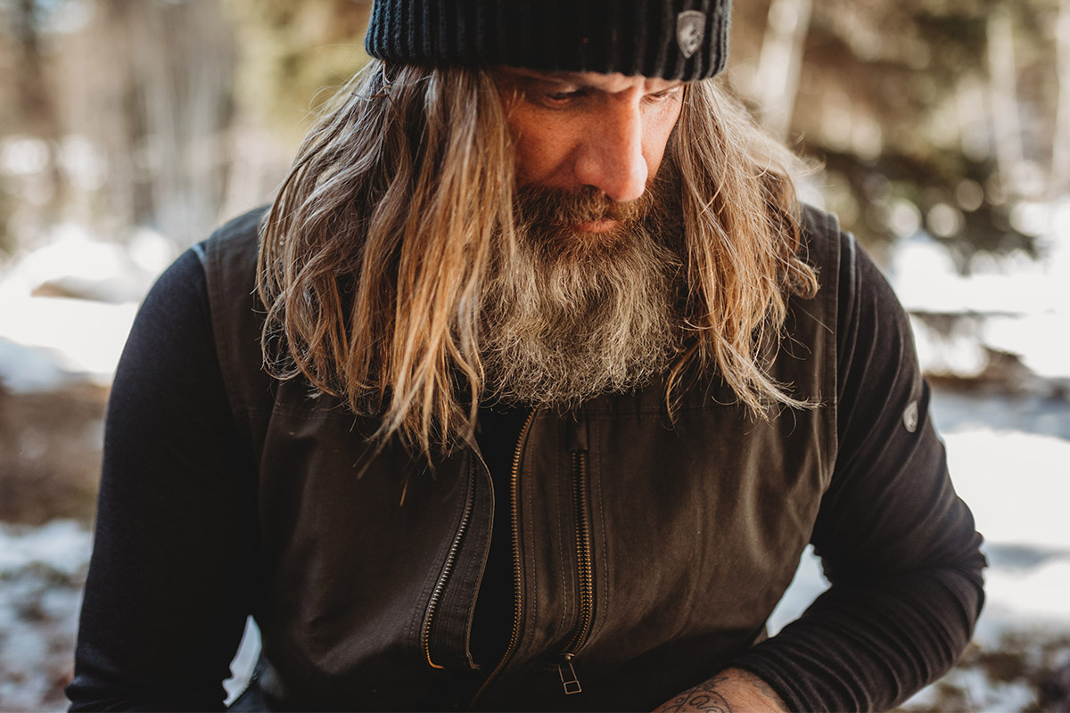 A bearded, long haired man wearing men's Burr Vest.