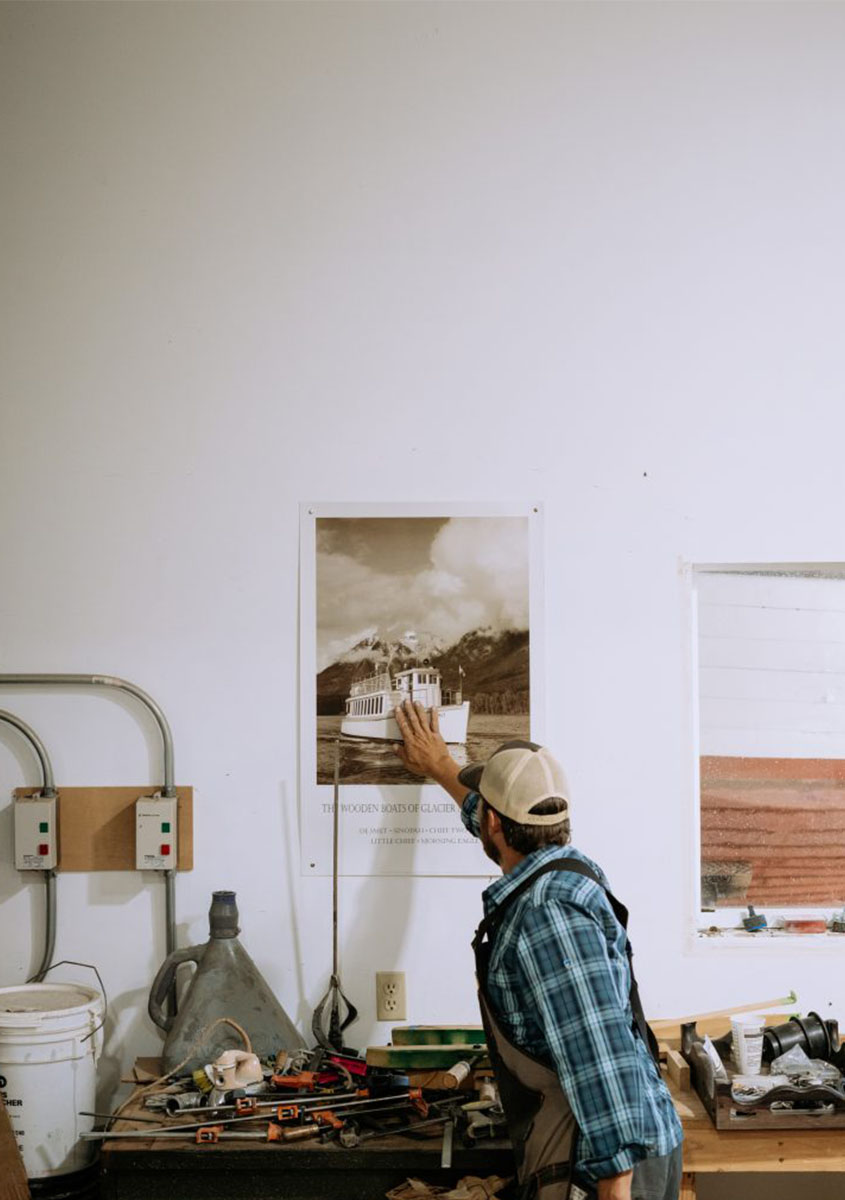 Man touching a poster of a boat. 