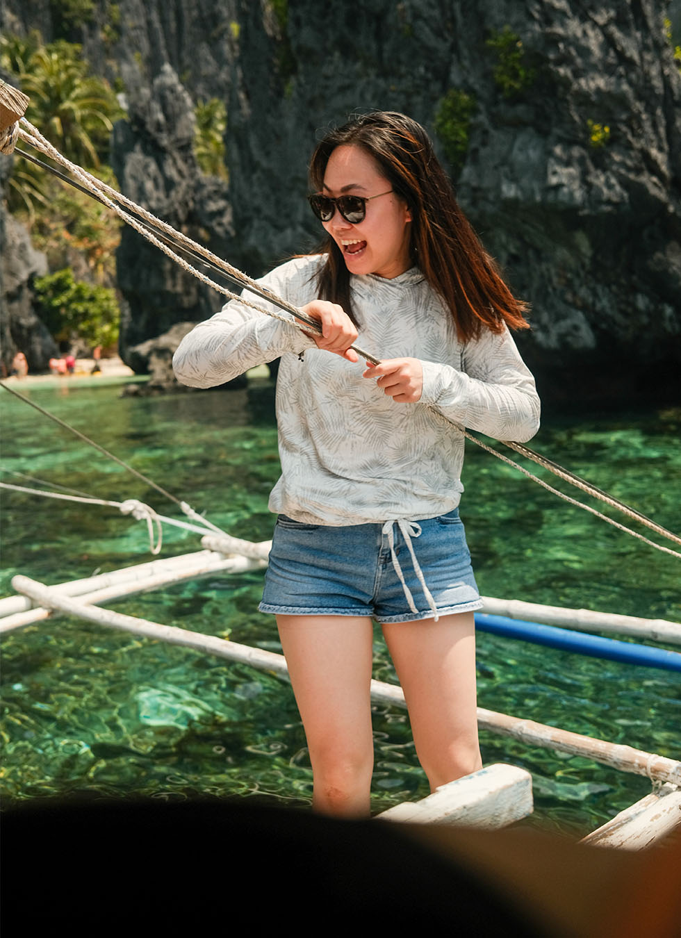 Maggie enjoying a boat ride in Philippines wearing KUHL women's summer clothing