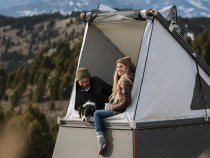 A man and a women in KUHL clothing enjoying camping in a rooftop tent