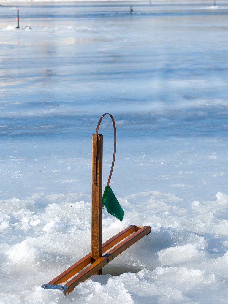 On the frozen Androscoggin River between Brunswick and Topsham Maine are several "tipups" used by people fishing through the ice.