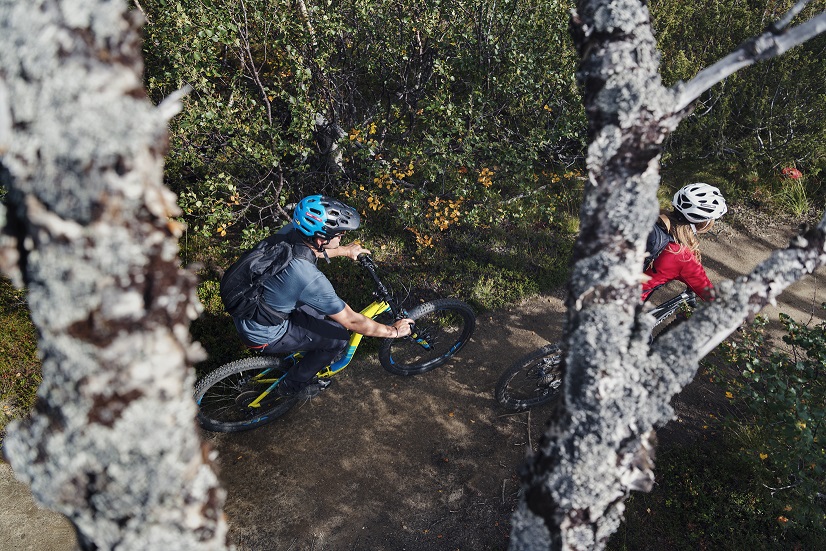 Mountain Biking For Beginners - A man and a woman riding a bike in KUHL cycling clothing.