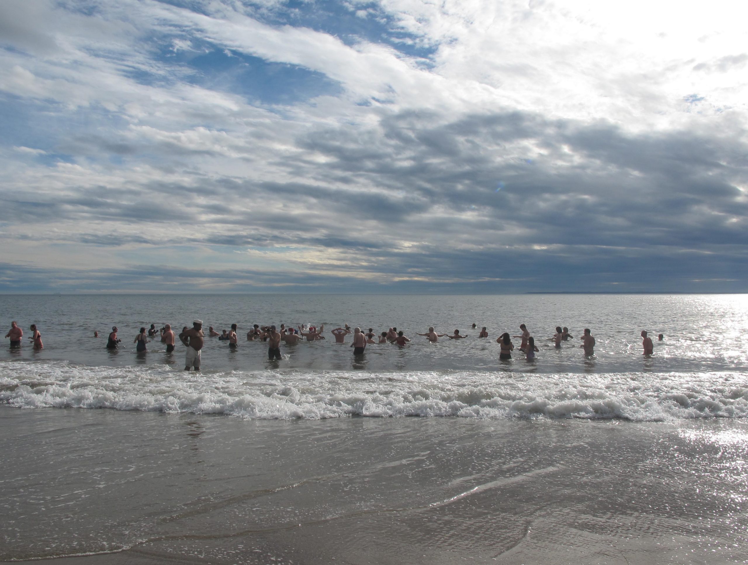 people bathing in water in winter