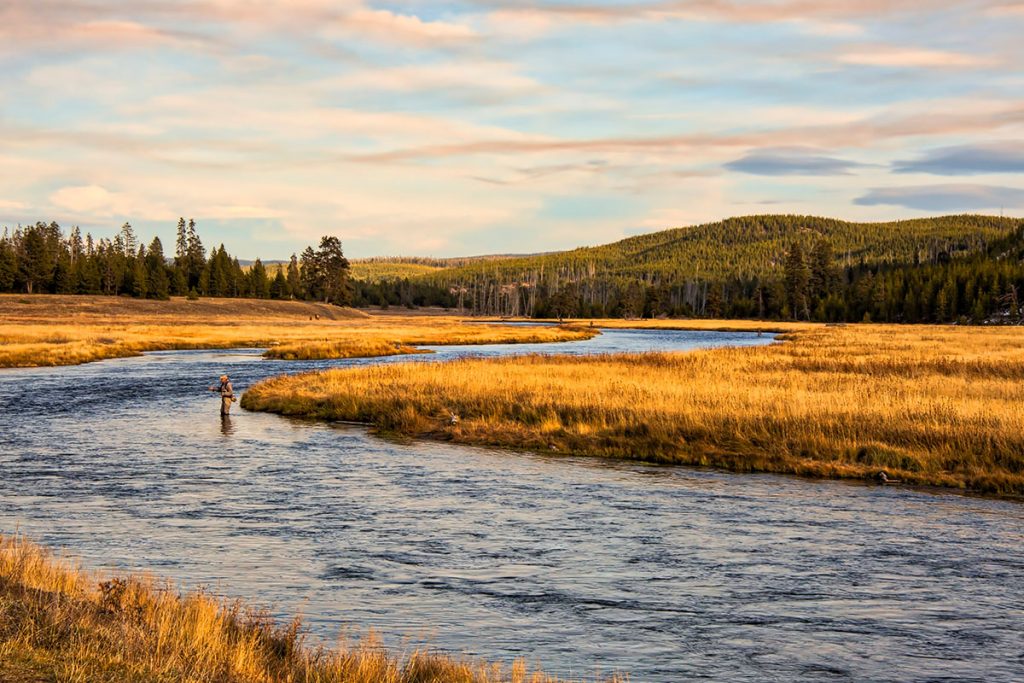 Man fishing on the river at sunset