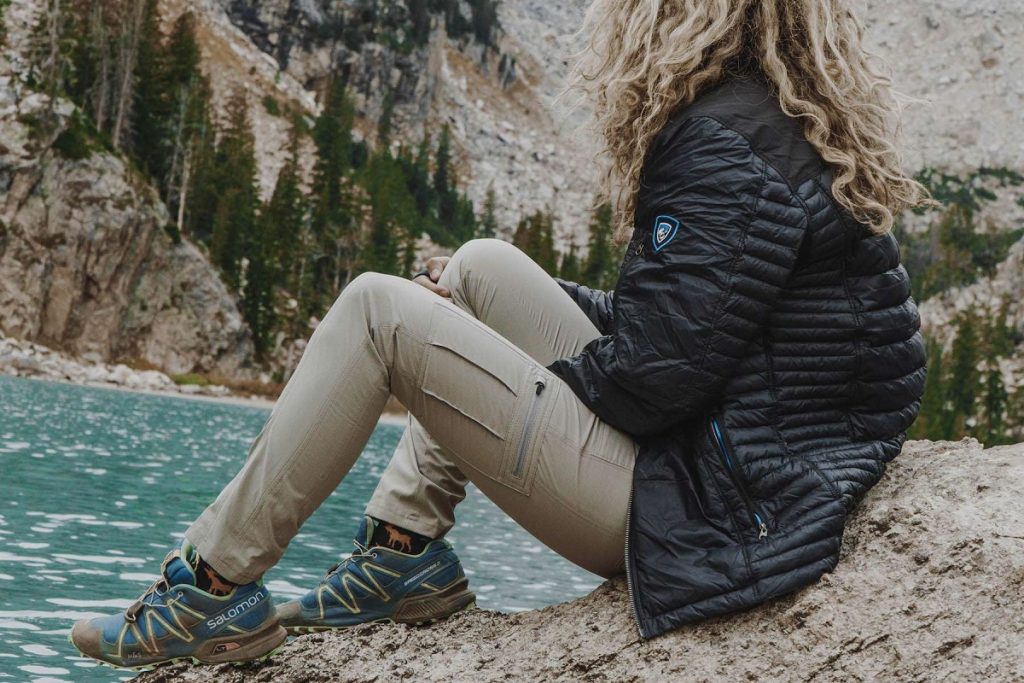 woman sitting on a rock next to the lake