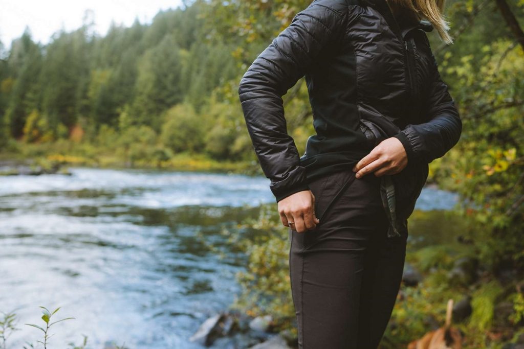 a woman zipping her pocket in the outdoors