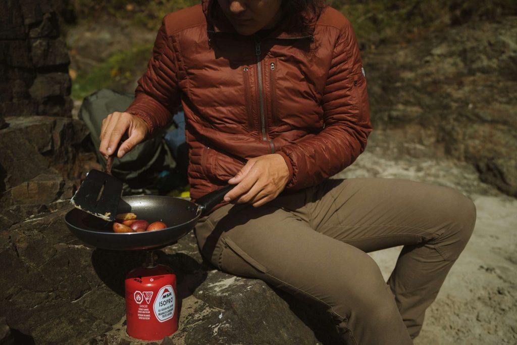 man in red jacket holding a pan