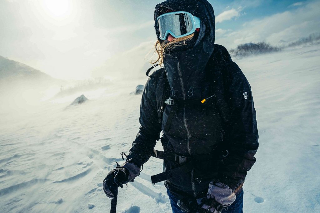 girl with googles on snowy trail holding ski poles