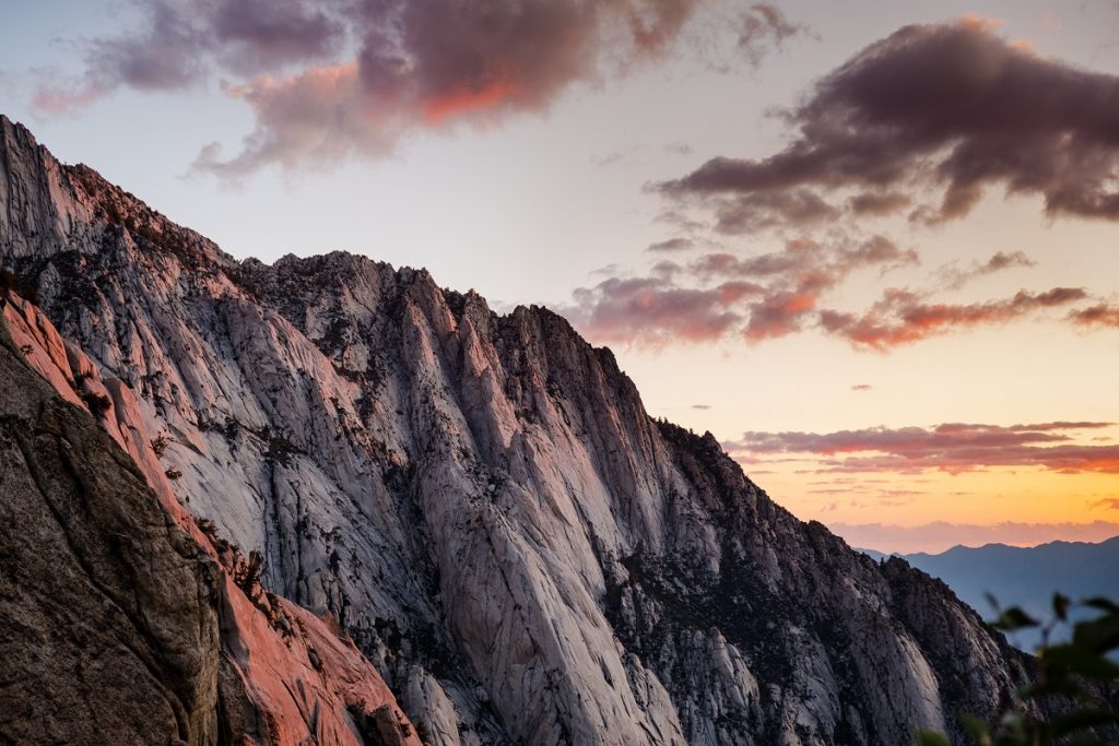 gray rock formation in front of white and yellow sky