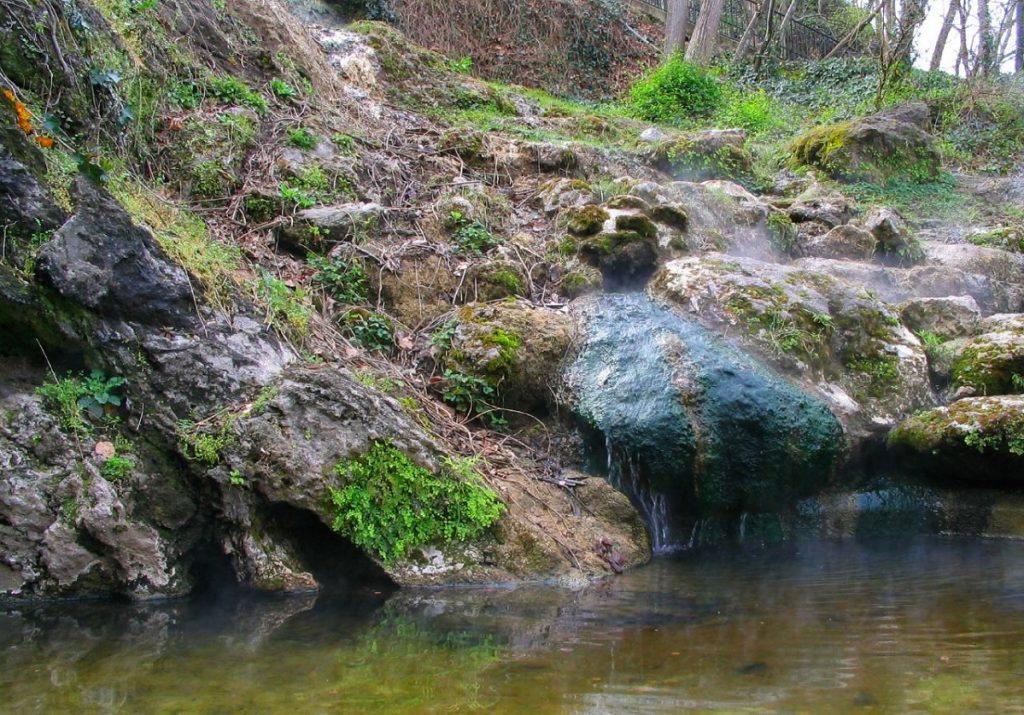 gray and green rocks over body of water