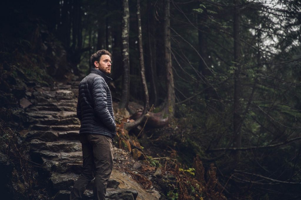 man in KÜHL pants and KÜHL jacket in the woods