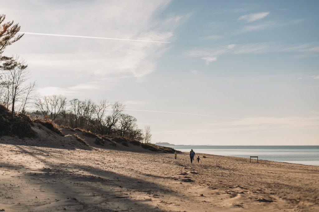 people on beach next to lake during daytime