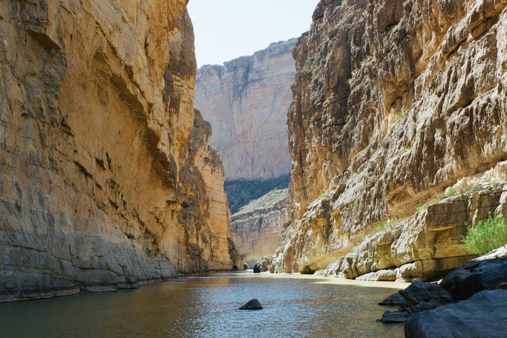 river between tall brown rock edges