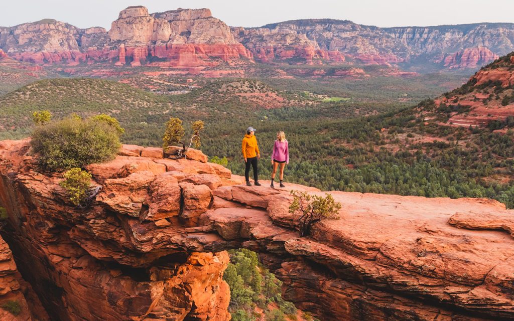 man in yellow KÜHL jacket standing on devils bridge