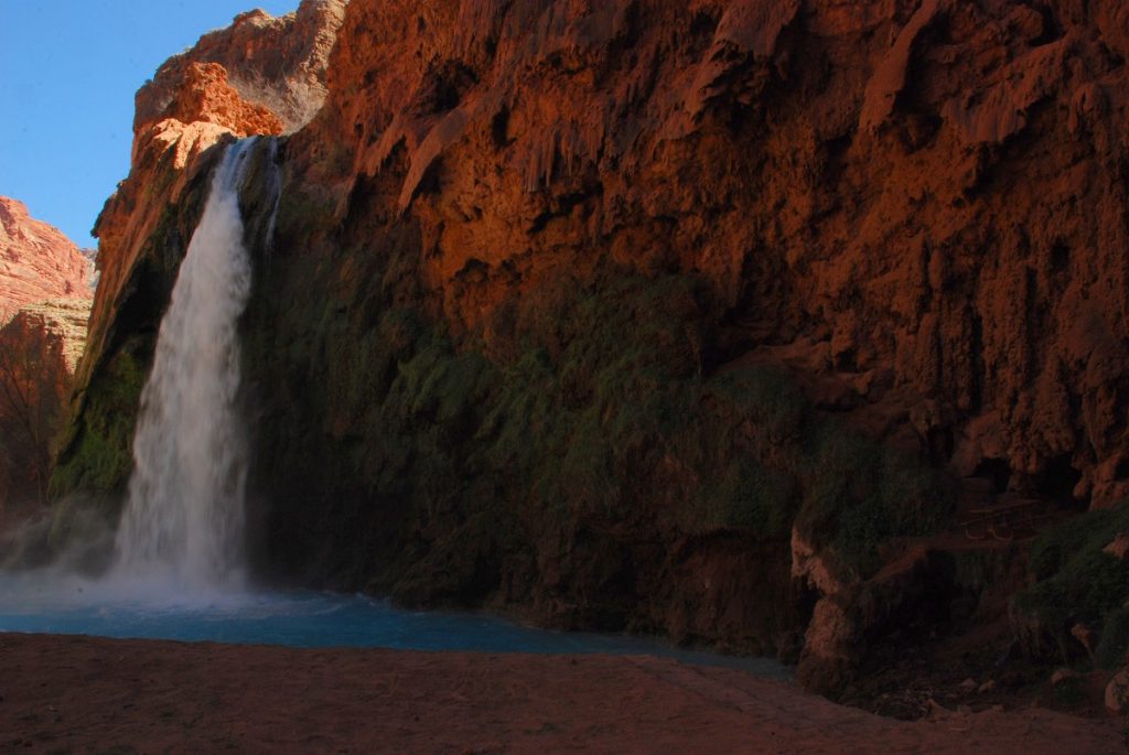 waterfall flowing from red rock formation