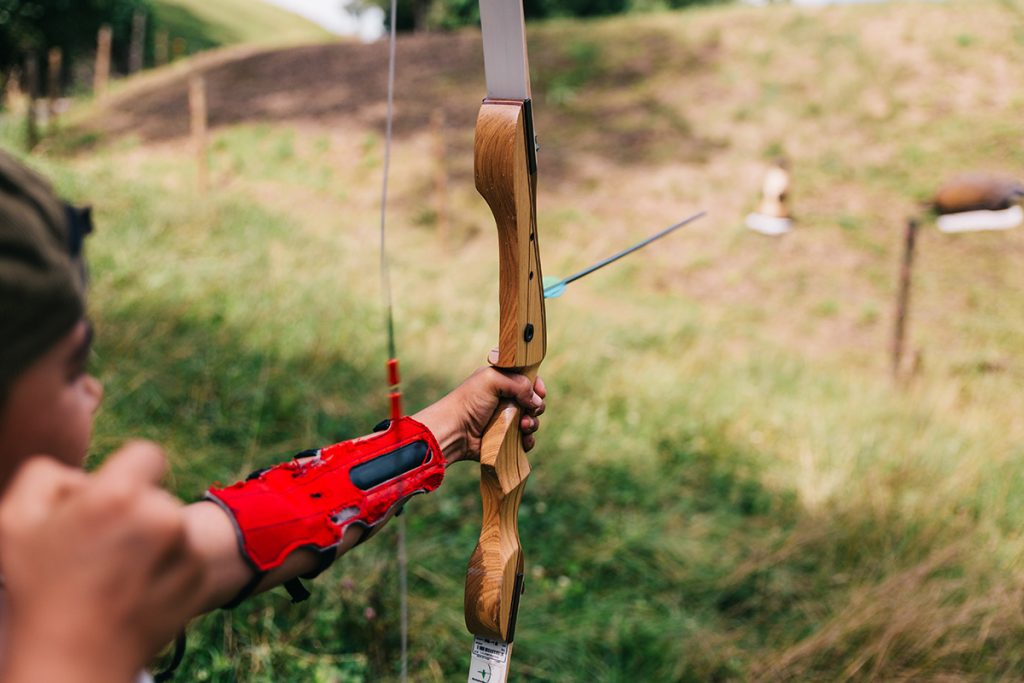 girl using a bow with red arm guard