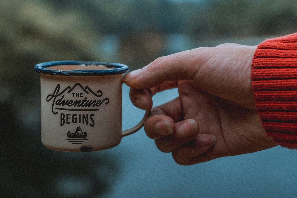 man holding a camping cup with liquid