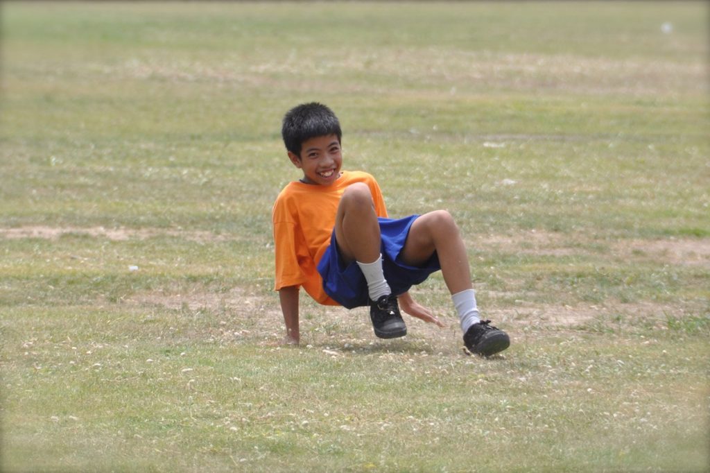 child doing a crab walk outdoors