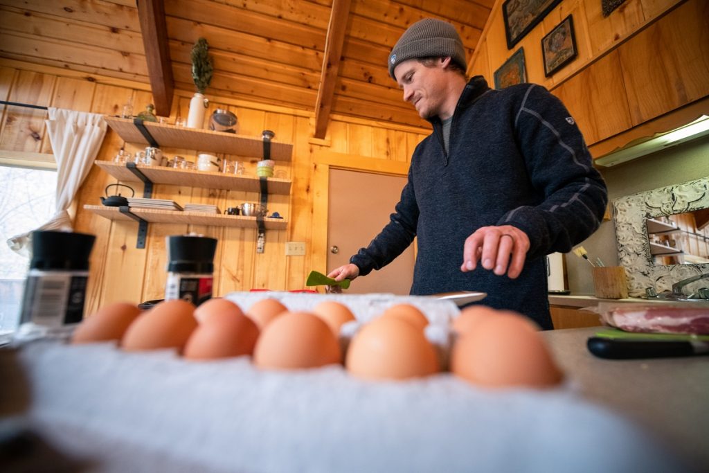 man in KÜHL Thor 1/4 Zip next to eggs