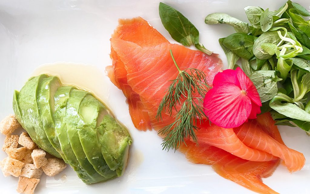 avocado salmon and garnish on white plate