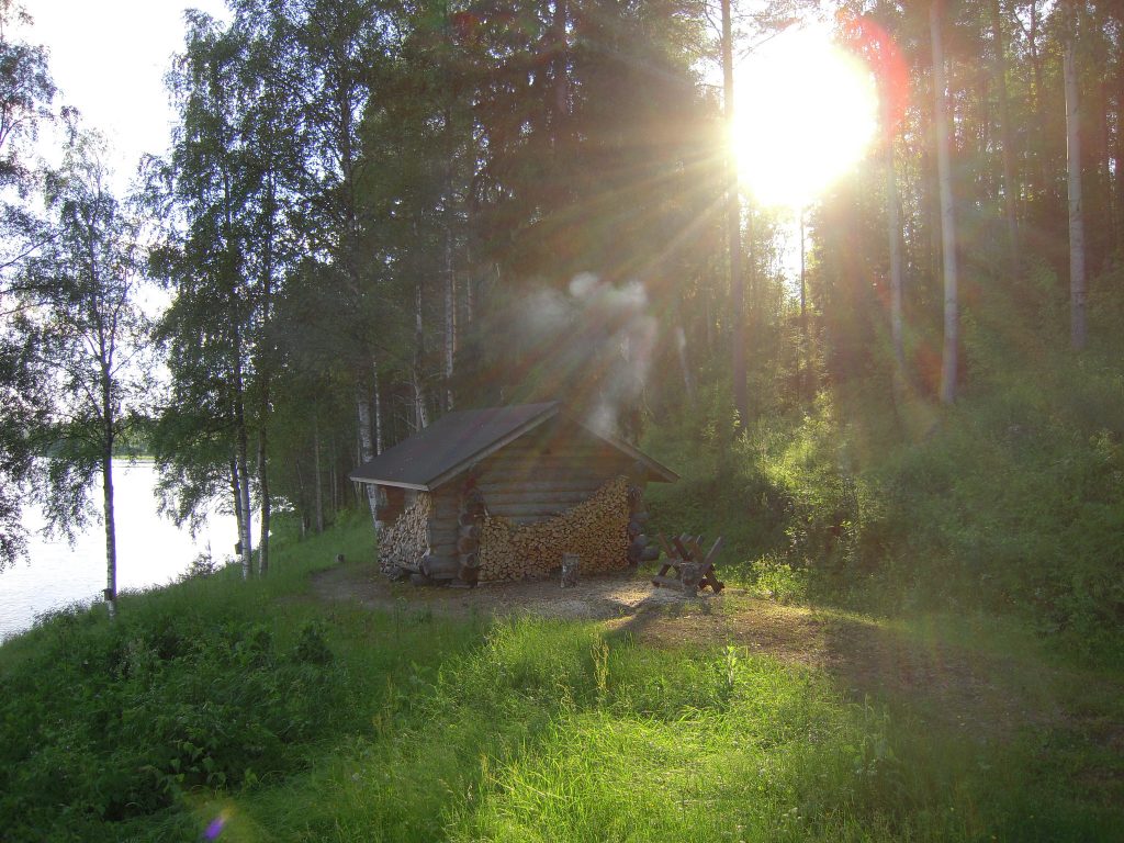 wooden shed smoking from the roof in the woods