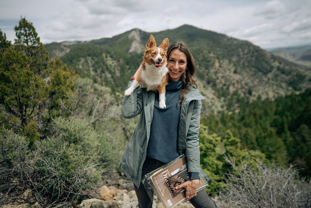 A Woman Holding a Dog On Her Back, outdoors