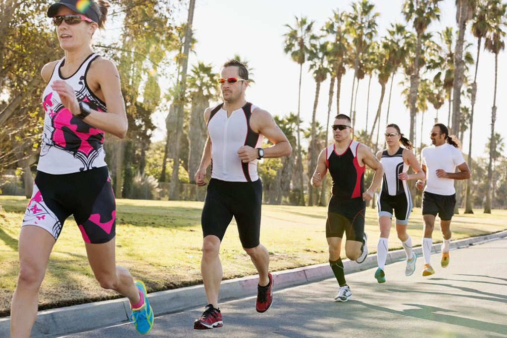 Female triathlete with competitors racing on street